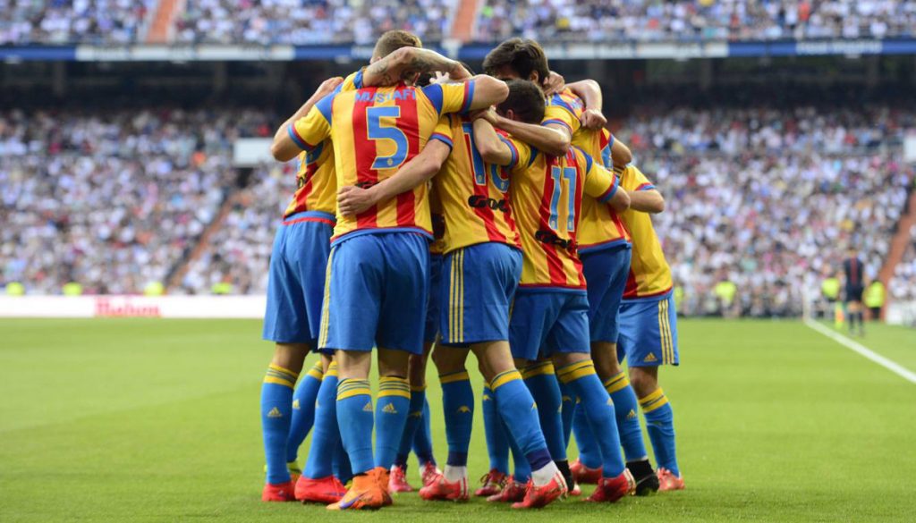 Valencia players celebrate their second goal during the Spanish league football match Real Madrid CF vs Valencia CF at the Santiago Bernabeu stadium in Madrid on May 9, 2015. AFP PHOTO/ GERARD JULIEN